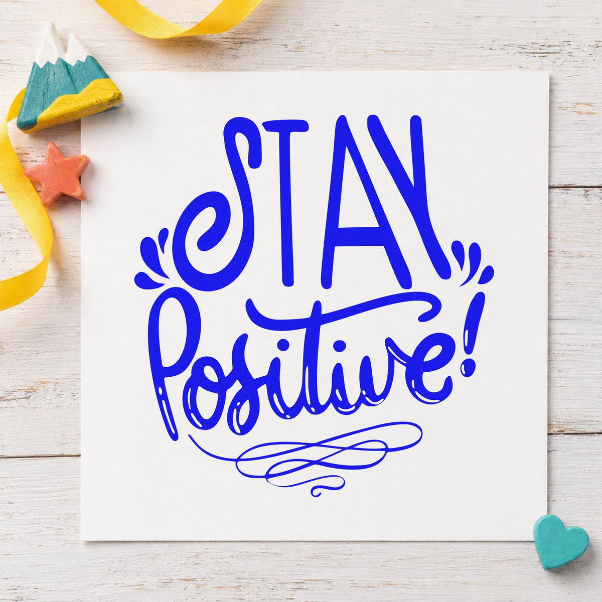 Stay Positive Decorative Script craft stamp imprinted in blue ink on paper, a design suited to framed locker room.