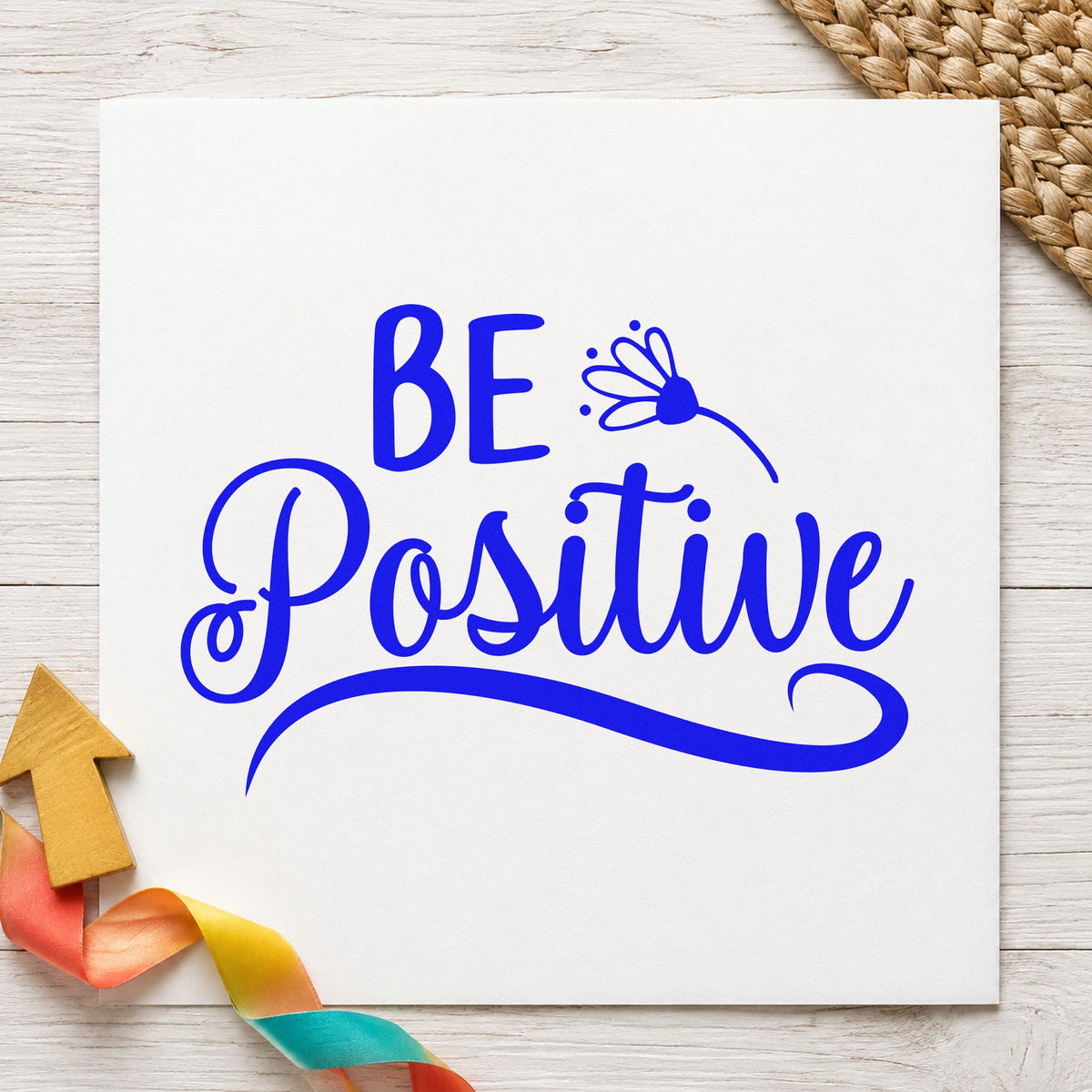 Be Positive Flower Script craft stamp in blue ink on cardstock, an easy option for apron bib printing.