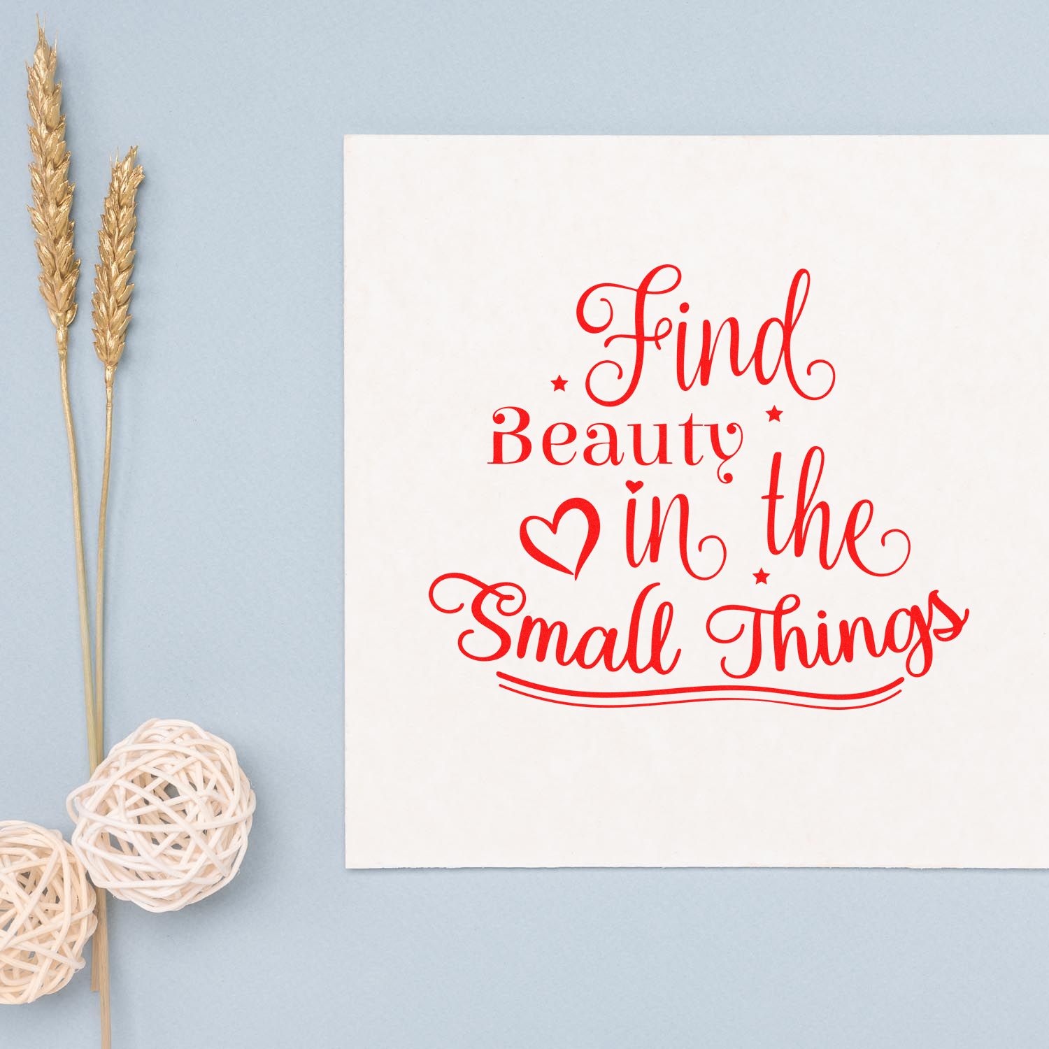 Custom rubber stamp quote design reading Find Beauty in the Small Things in red script on white paper.