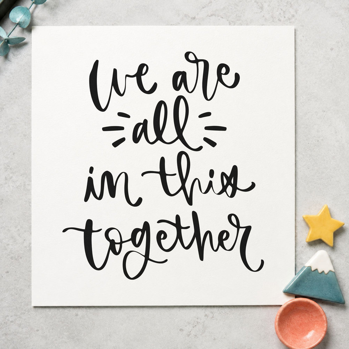 We Are All In Together craft stamp imprint in black ink on a handmade project, one idea being dish share gift tags.