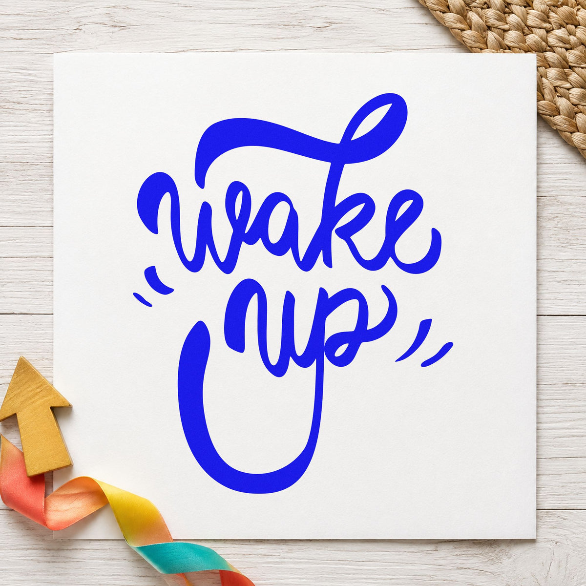 Wake Up Bold Script craft stamp imprinted in blue ink on paper, a design suited to framed bake room.