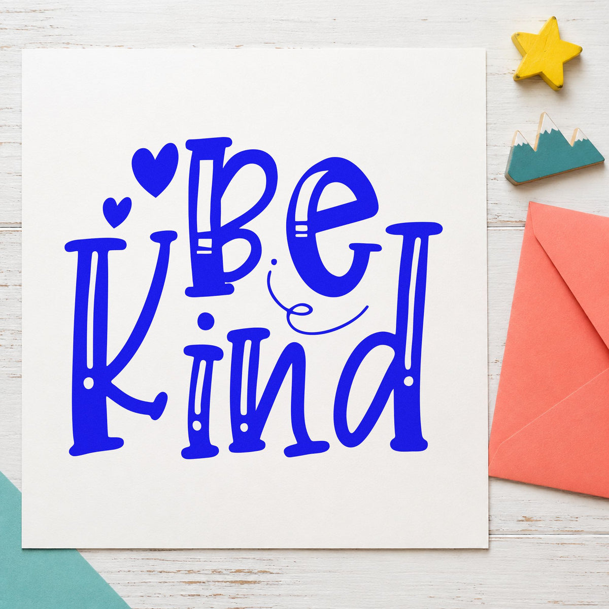 Be Kind Decorative Hearts craft stamp in blue ink on cardstock, an easy option for volunteer tee printing.