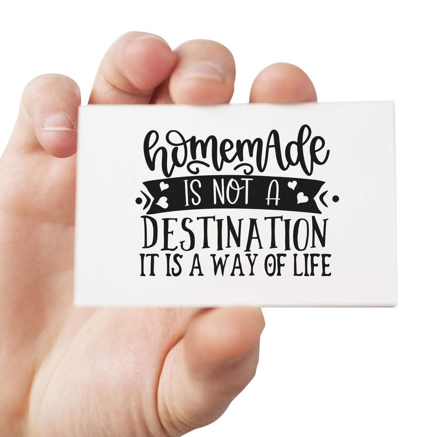 Hand holding custom rubber stamp with Handmade is not a destination, it is a way of life quote for crafting and packaging.