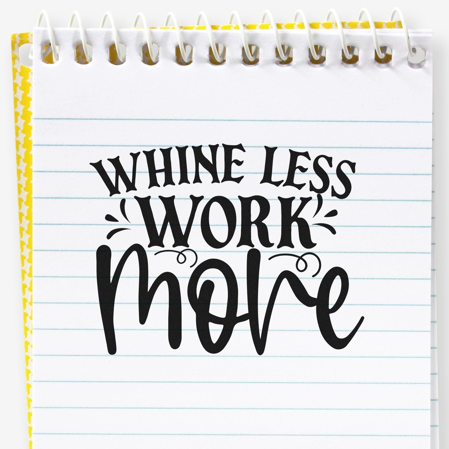 Whine less, work more motivational rubber stamp imprint on lined notebook paper.