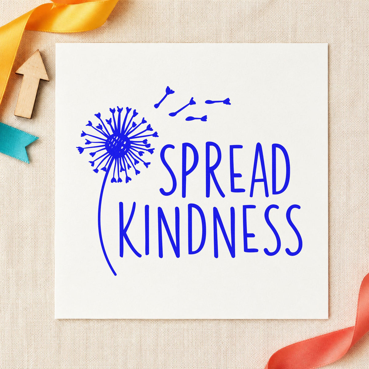 Spread Kindness Dandelion Seeds craft stamp imprinted in blue ink on paper, a design suited to framed garden gate.