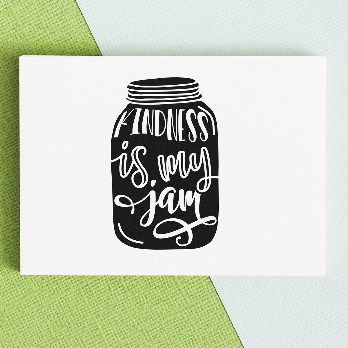 Kindness Is My Jam Jar Lettering Premium Wooden Stamp - Vintage Pro imprint stamped in black ink. The phrase "Kindness is my jam" appears in light lettering inside a dark illustrated mason jar.