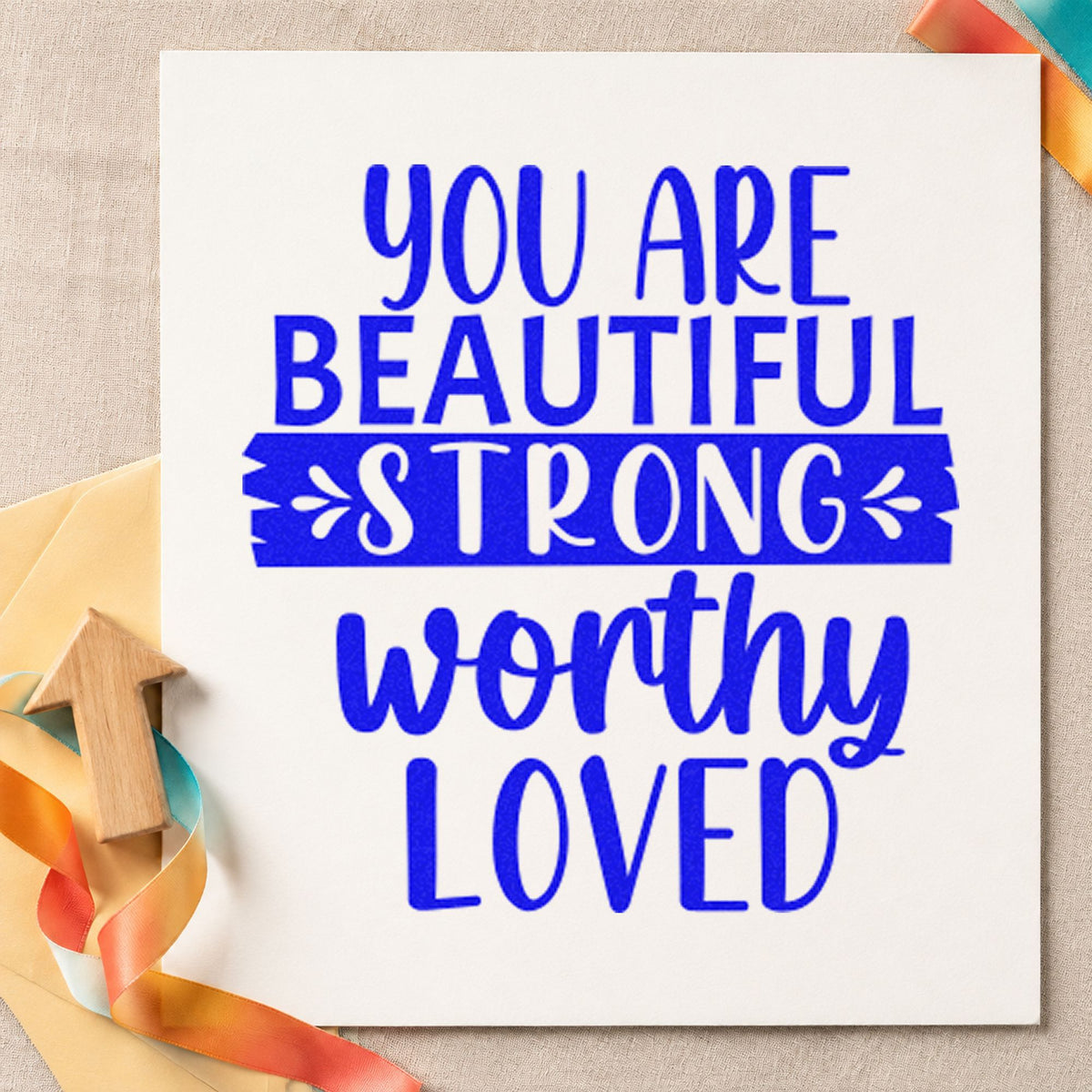 Beautiful Strong Worthy Loved craft stamp in blue ink on cardstock, an easy option for sleep mask printing.