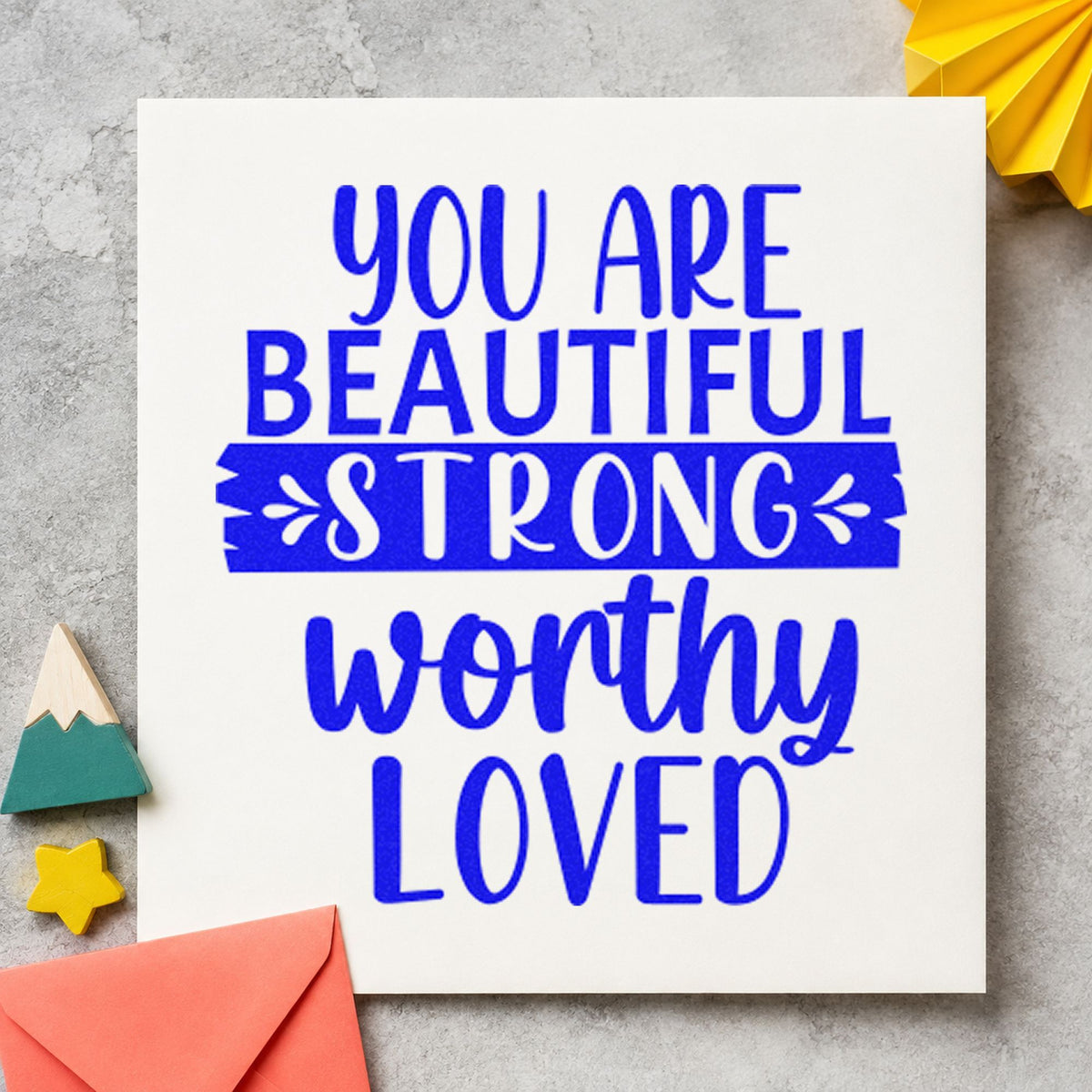 Beautiful Strong Worthy Loved craft stamp imprinted in blue ink on paper, a design suited to framed common room.