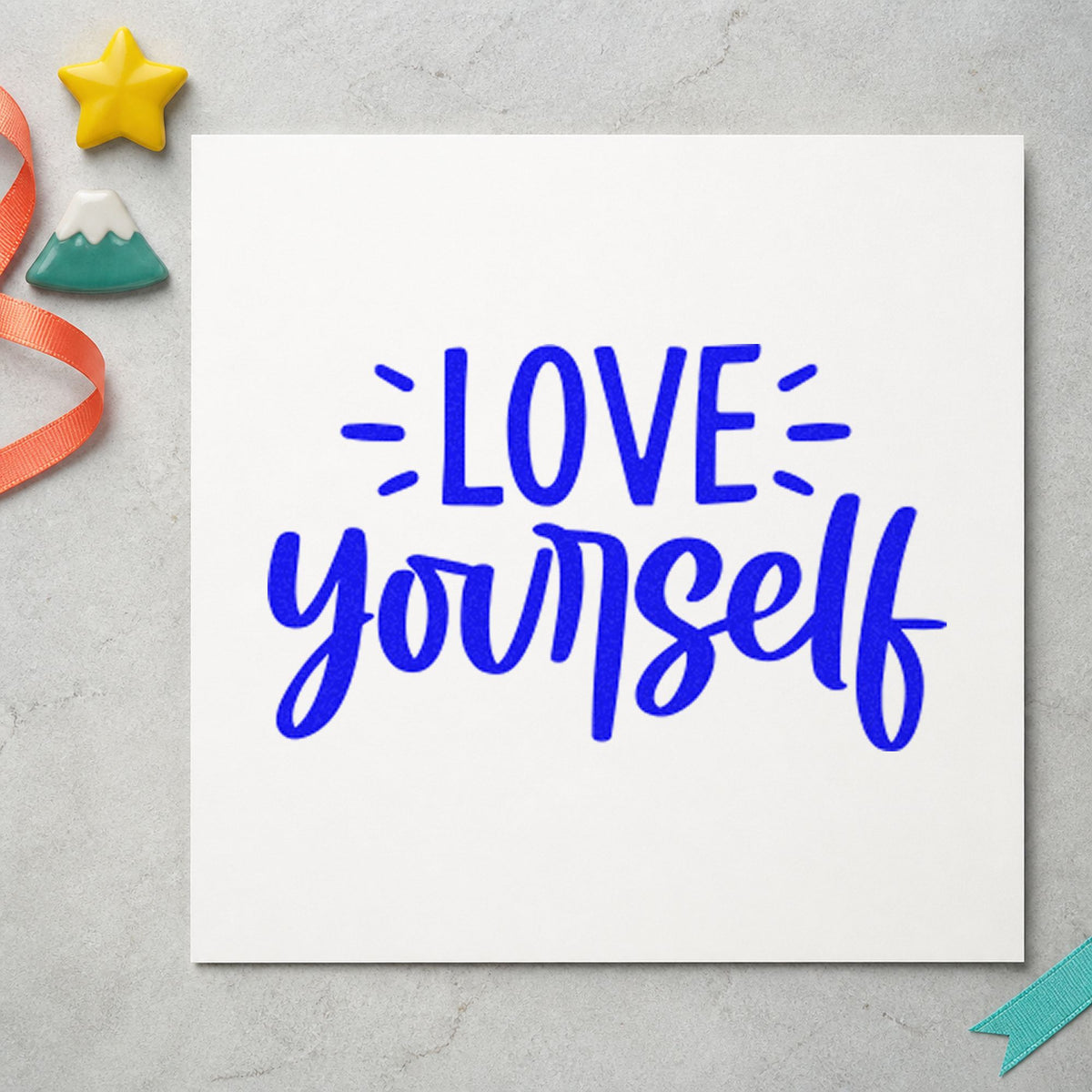 Love Yourself Bold Script craft stamp in blue ink on cardstock, an easy option for shop apron printing.