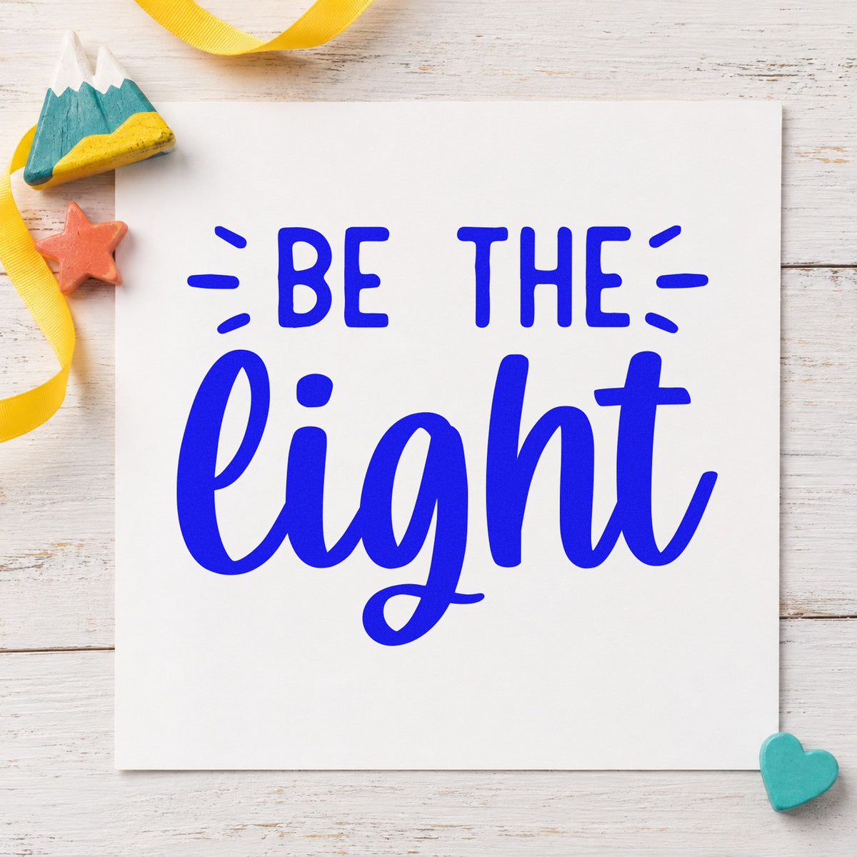 Be The Light Script craft stamp in blue ink on cardstock, an easy option for work apron printing.