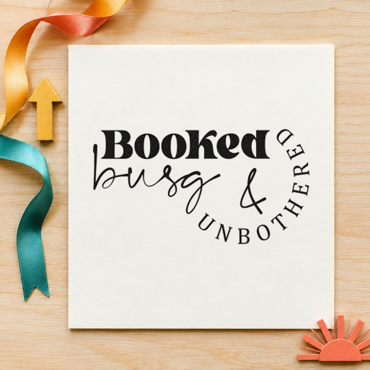 Booked Busy And Unbothered craft stamp imprint in black ink on a handmade project, one idea being aftercare gift tags.