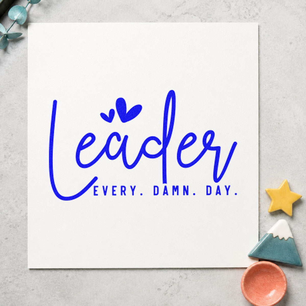 Leader Every Damn Day craft stamp imprinted in blue ink on paper, a design suited to framed board room.