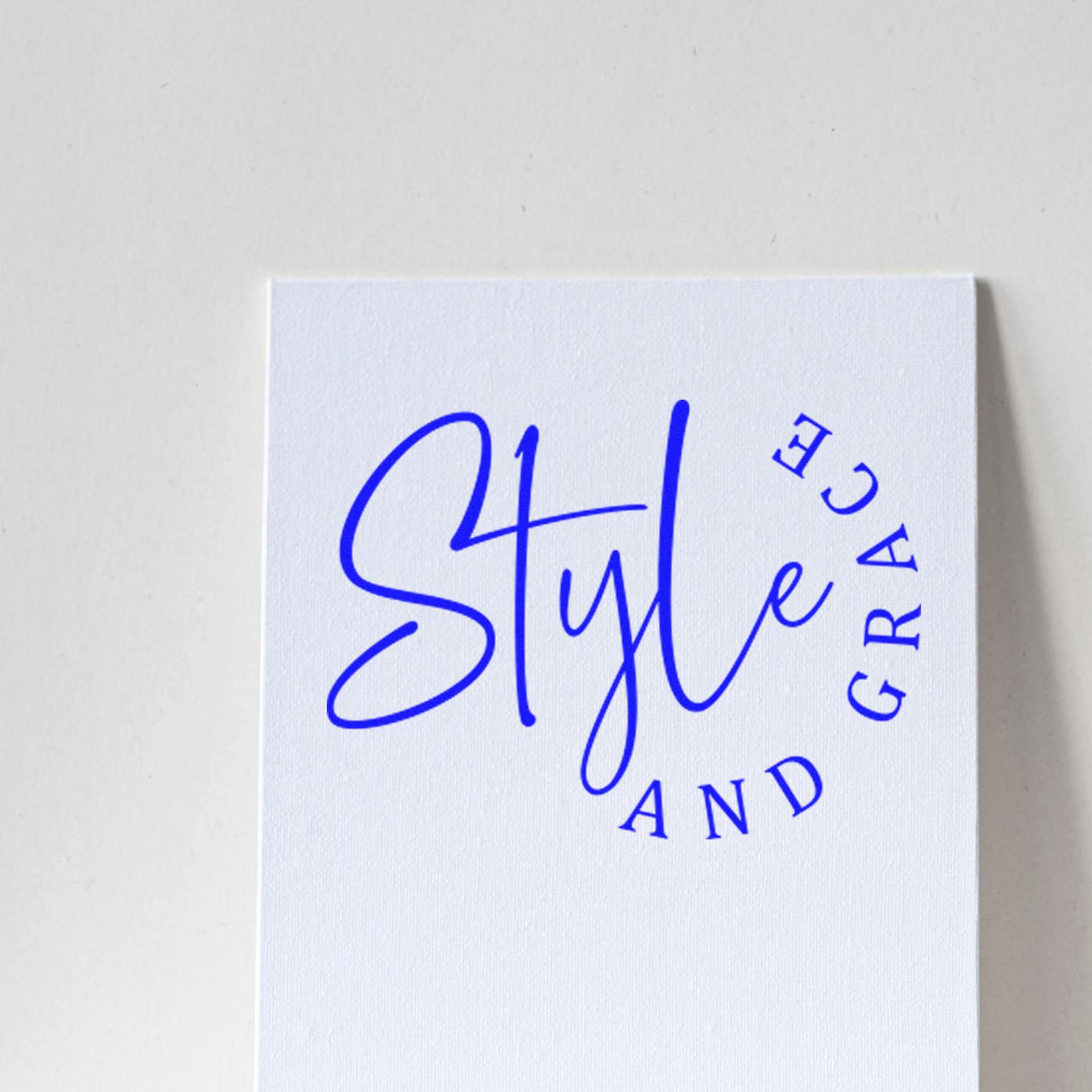 Custom blue rubber stamp logo reading Style and Grace on white cardstock for boutique branding.