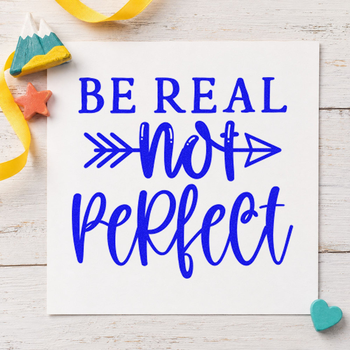 Be Real Not Perfect craft stamp in blue ink on cardstock, an easy option for oven mitt printing.