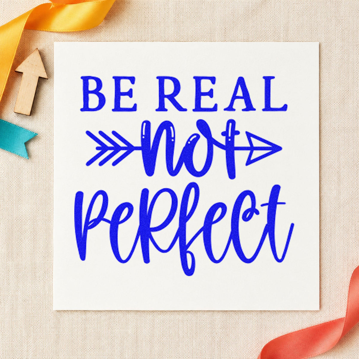 Be Real Not Perfect craft stamp imprinted in blue ink on paper, a design suited to framed kitchen corner.