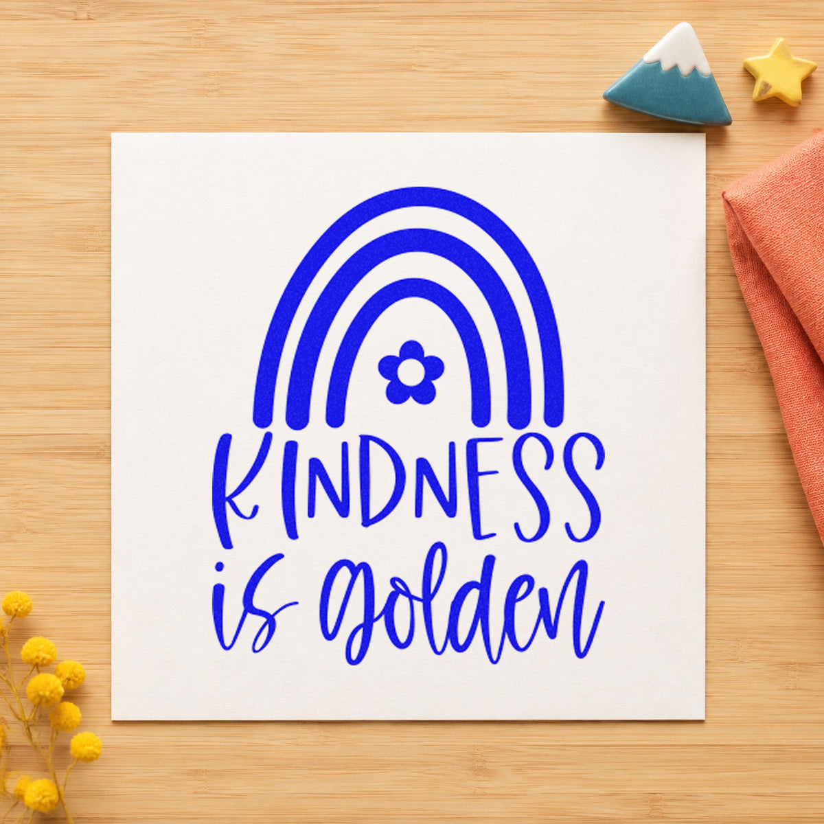 Kindness Is Golden Rainbow craft stamp imprinted in blue ink on paper, a design suited to framed school entry.