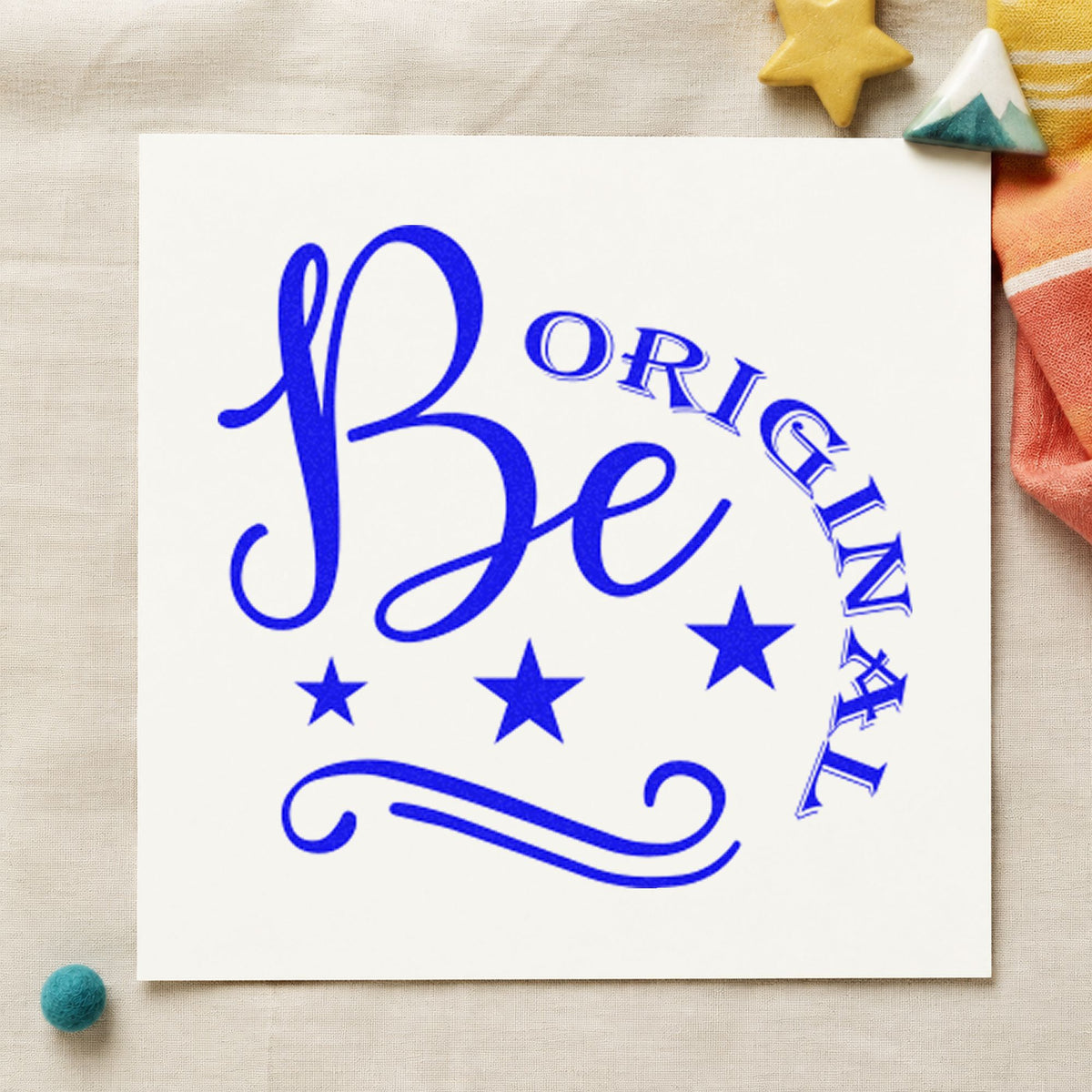 Be Original Stars Flourish craft stamp in blue ink on cardstock, an easy option for work apron printing.