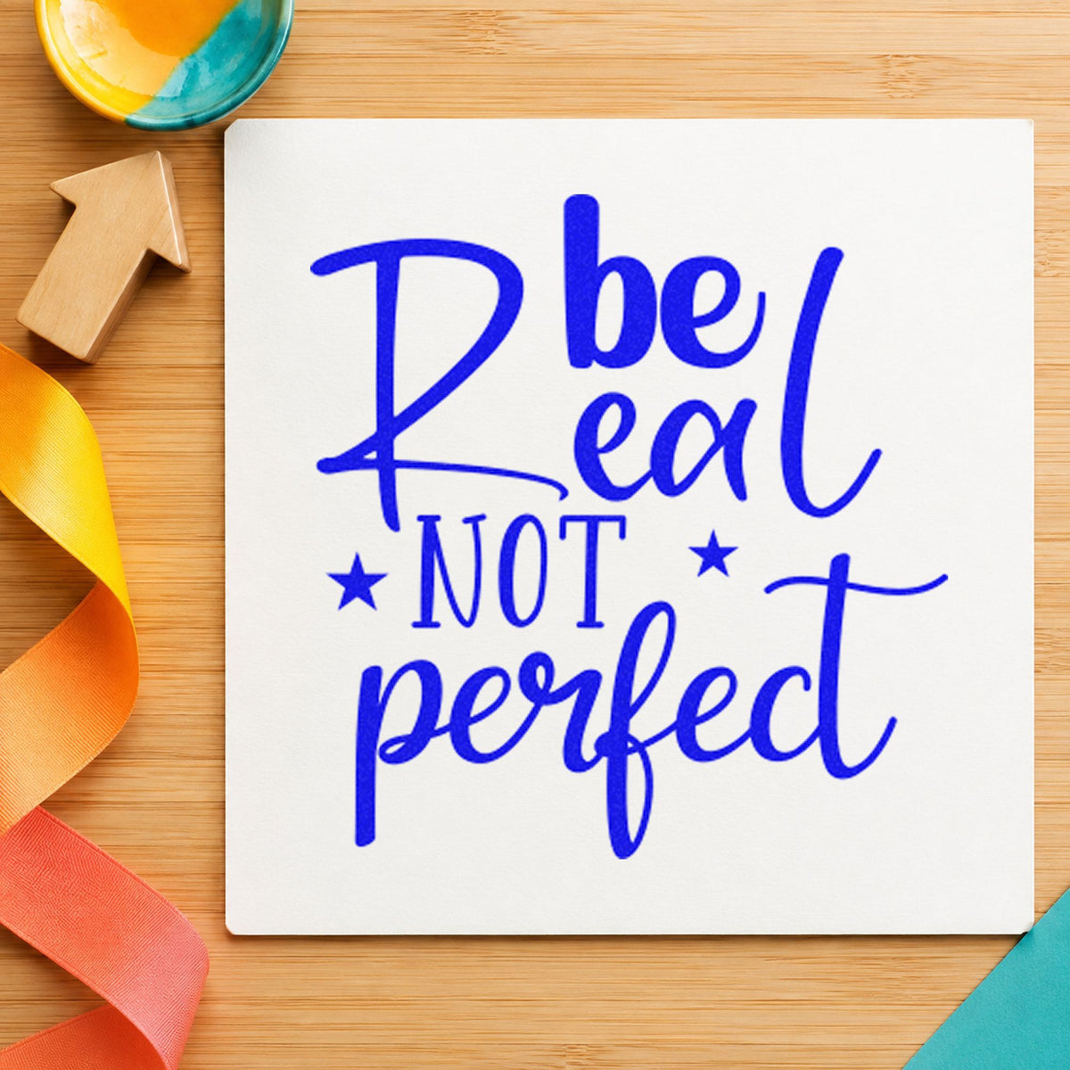 Be Real Not Perfect Stars craft stamp imprinted in blue ink on paper, a design suited to framed craft room.
