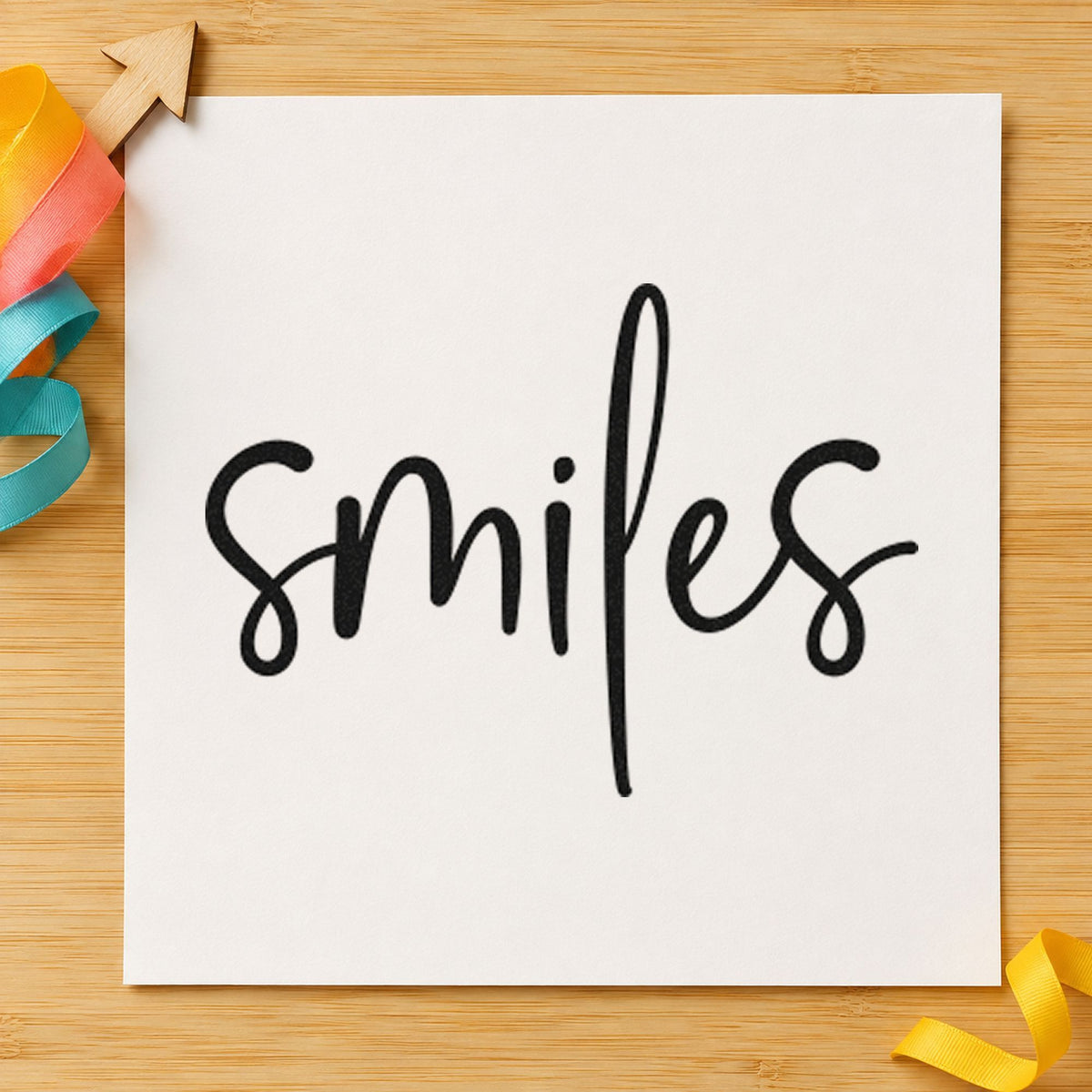 Smiles Simple Brush Script craft stamp imprint in black ink on a handmade project, one idea being print strip gift tags.