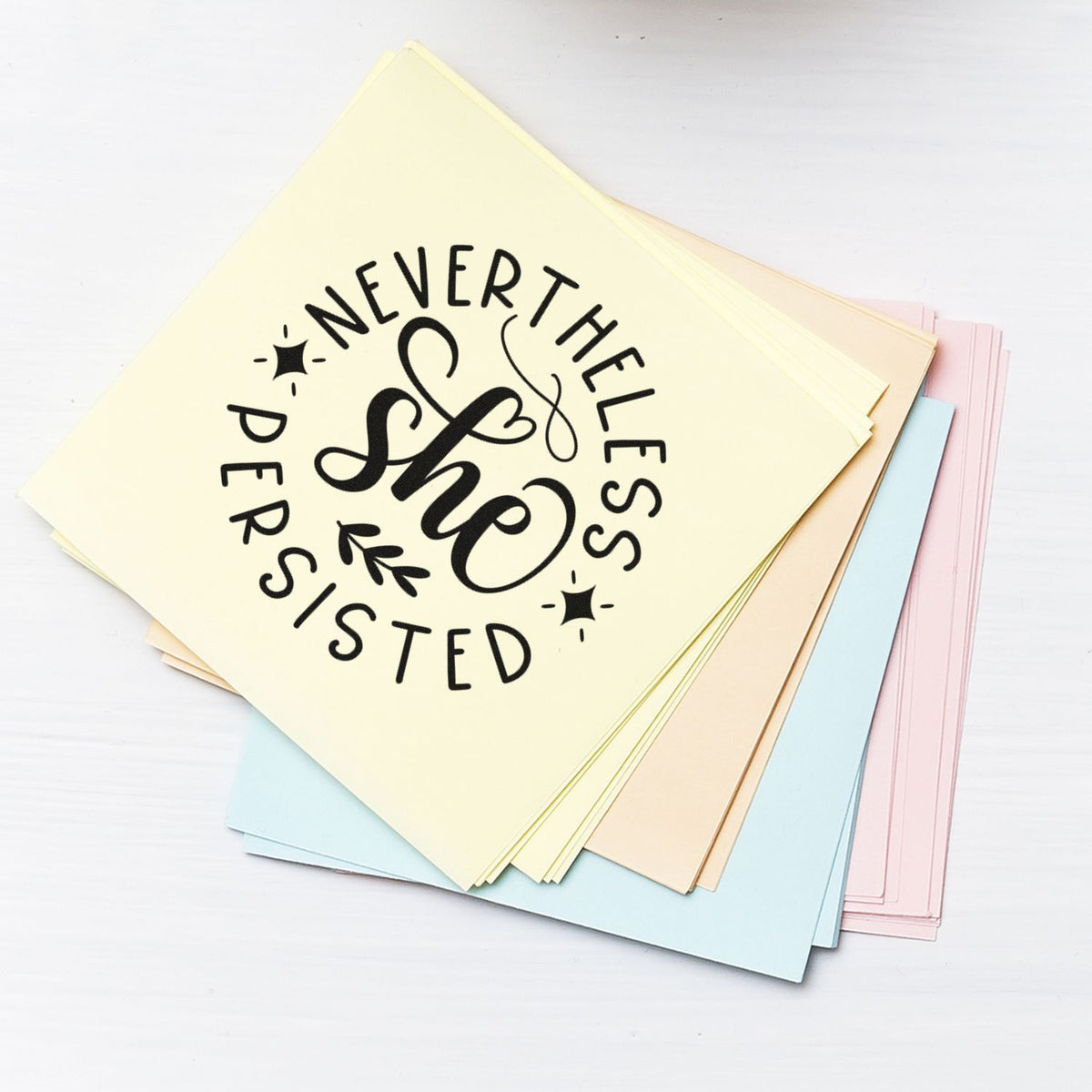 Nevertheless She Persisted Circle Premium Wood-Mounted Stamp - Vintage Pro imprint stamped in black ink. The words "Nevertheless she persisted" form a circular composition with sparkles and a leafy sprig.