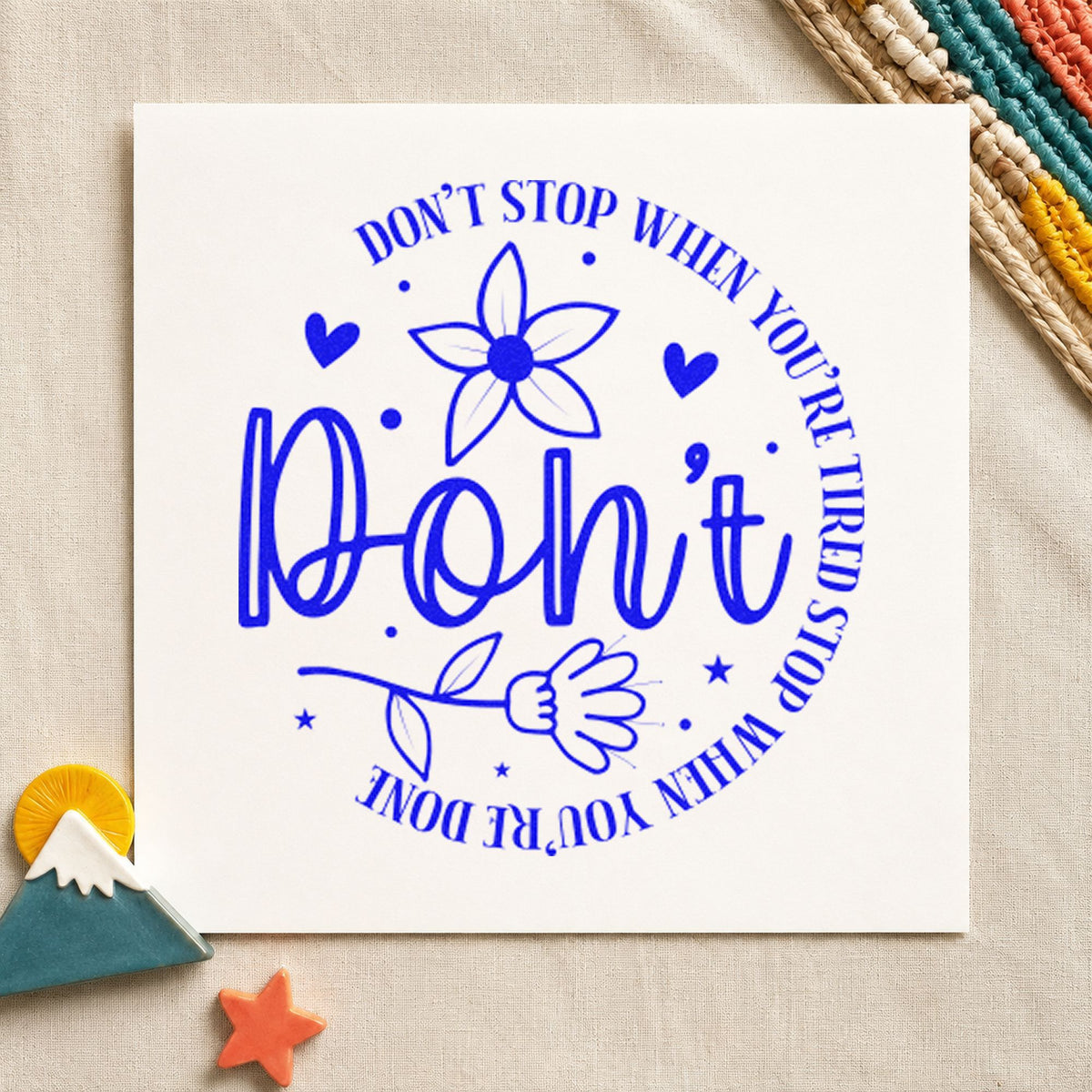 Don't Stop When Tired Floral craft stamp in blue ink on cardstock, an easy option for desk cushion printing.