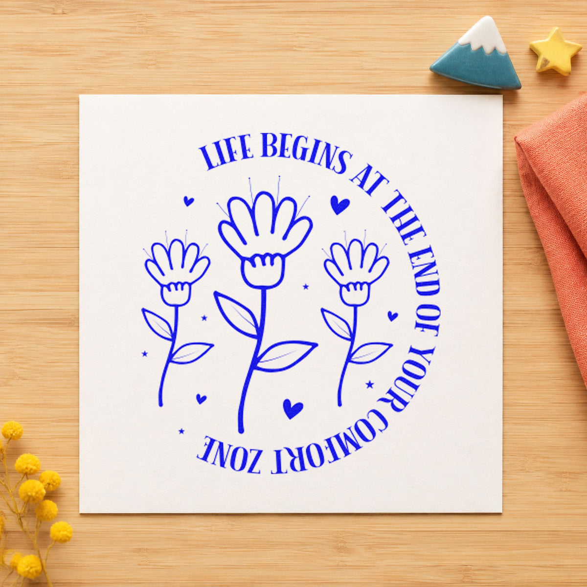 Life Begins Comfort Zone Flowers craft stamp imprinted in blue ink on paper, a design suited to framed studio barre.