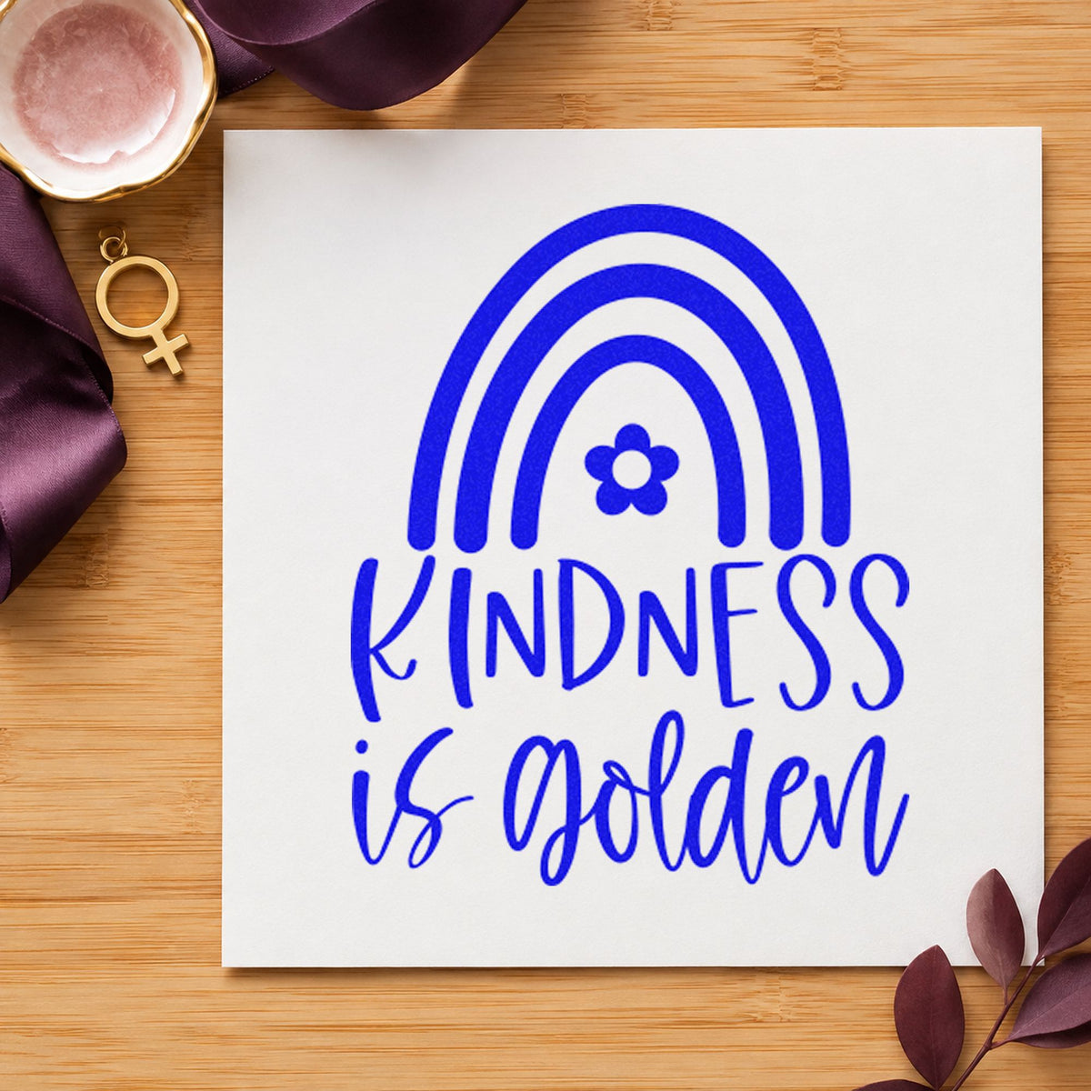 Kindness Golden Flower Rainbow craft stamp in blue ink on cardstock, an easy option for bench cushion printing.