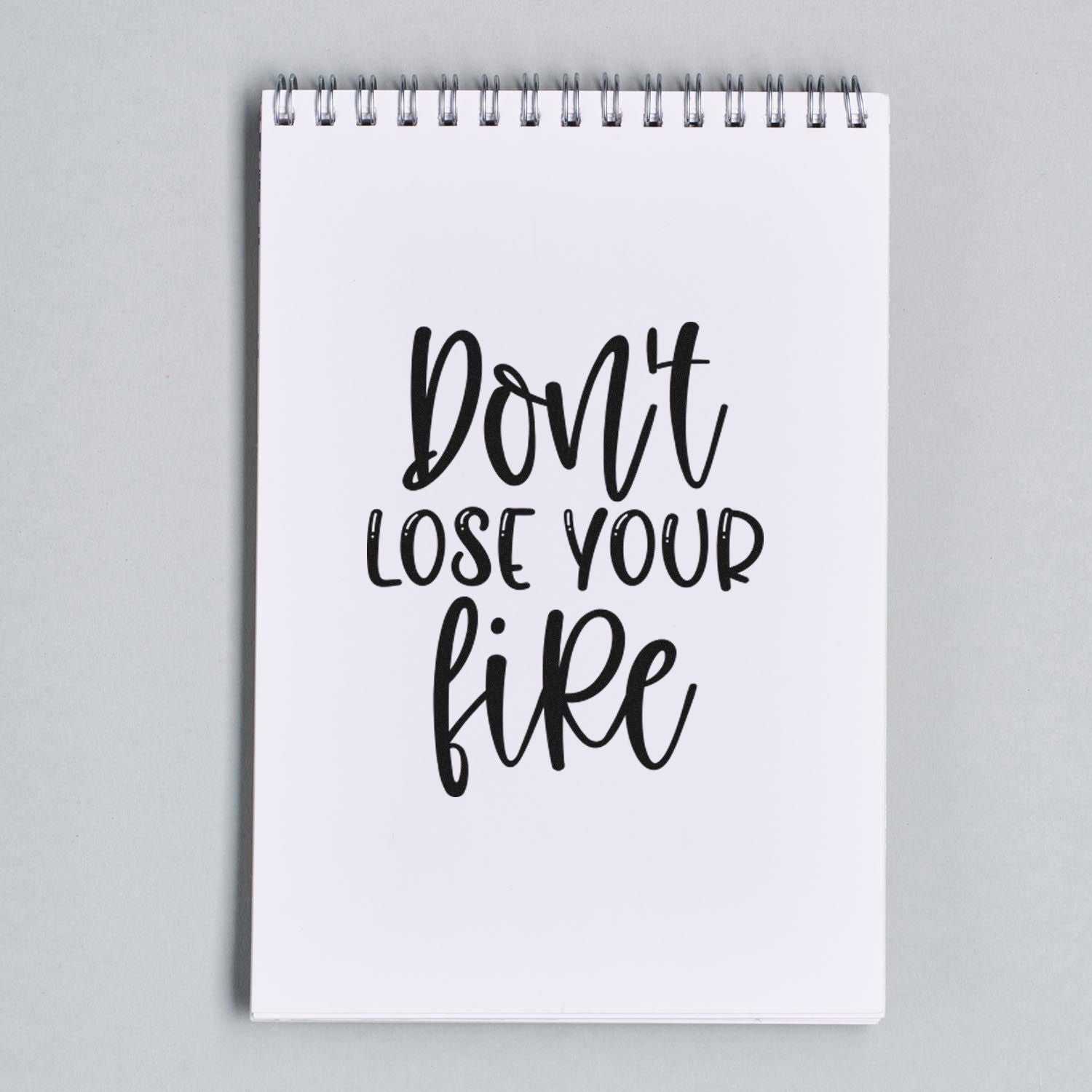 Dont lose your fire quote rubber stamp design on a spiral notebook, black ink motivational design