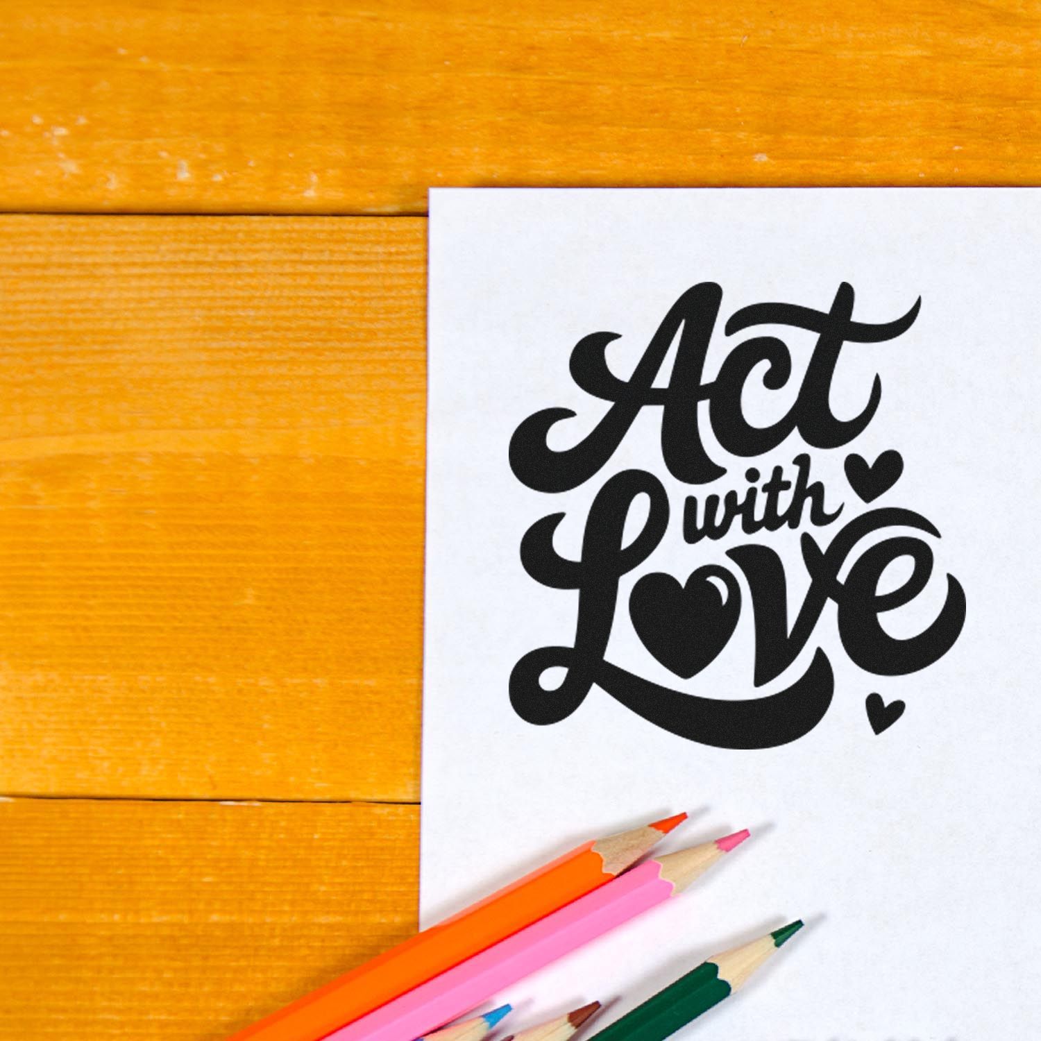 Act with Love rubber stamp design on paper with colored pencils, ideal for craft and stationery branding.