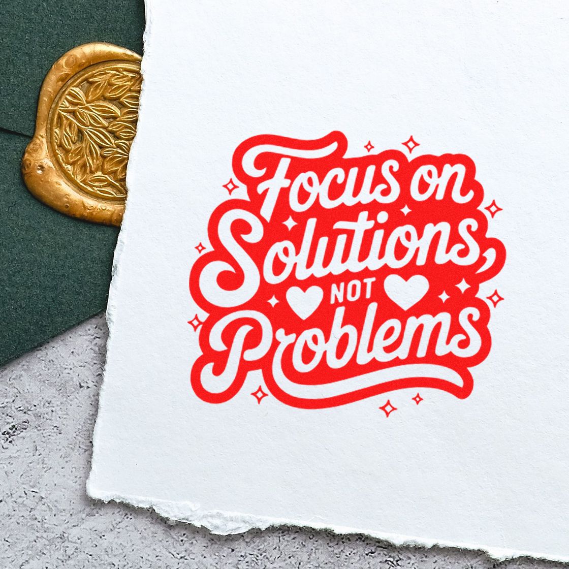 Custom motivational rubber stamp reading Focus on Solutions Not Problems in bold red script.
