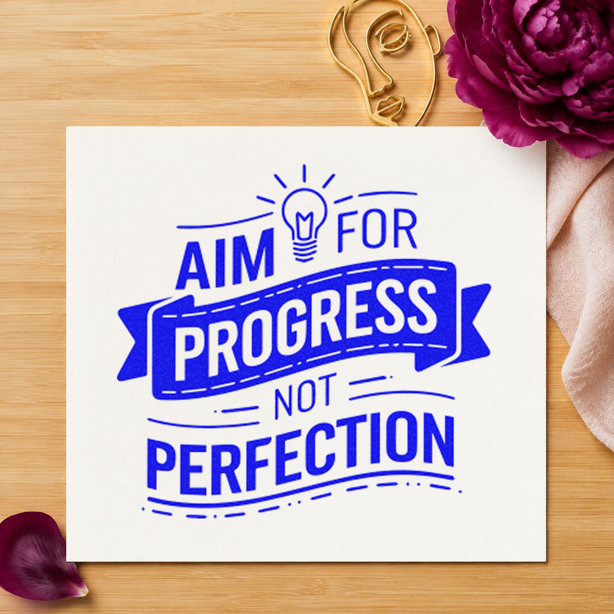 Aim Progress Not Perfection craft stamp in blue ink on cardstock, an easy option for desk mat printing.