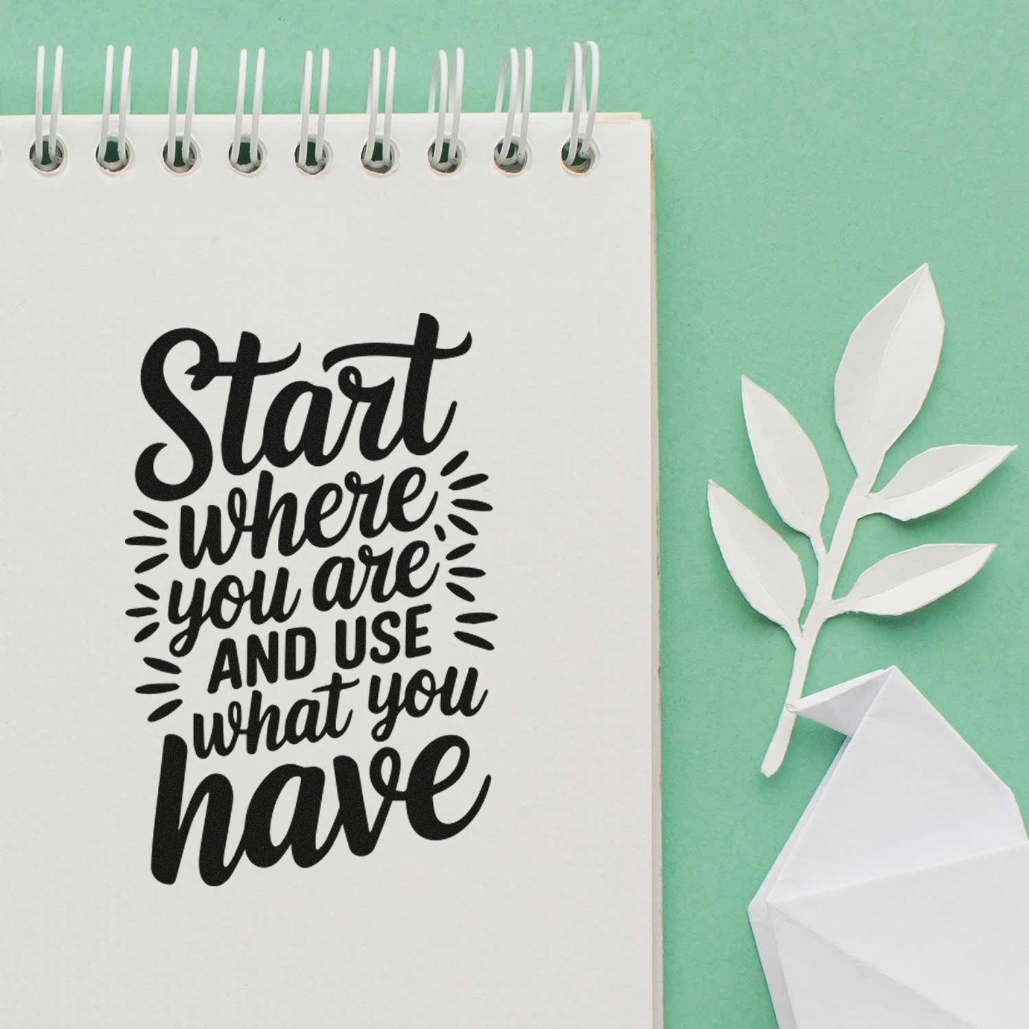 Motivational rubber stamp quote Start where you are and use what you have displayed on a notebook with paper leaf craft.
