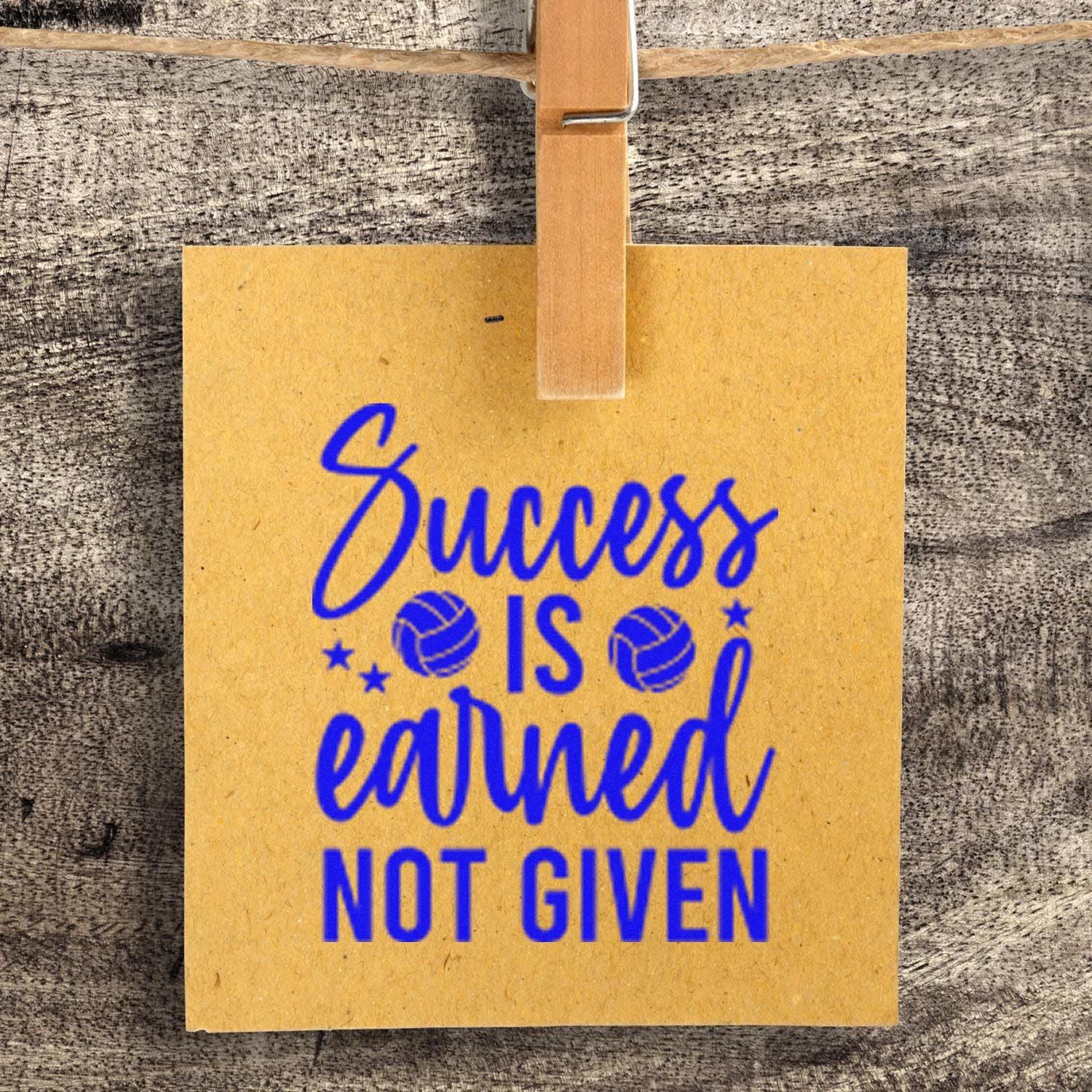 Custom rubber stamp imprint reading Success is earned, not given with volleyball icons on kraft paper card.