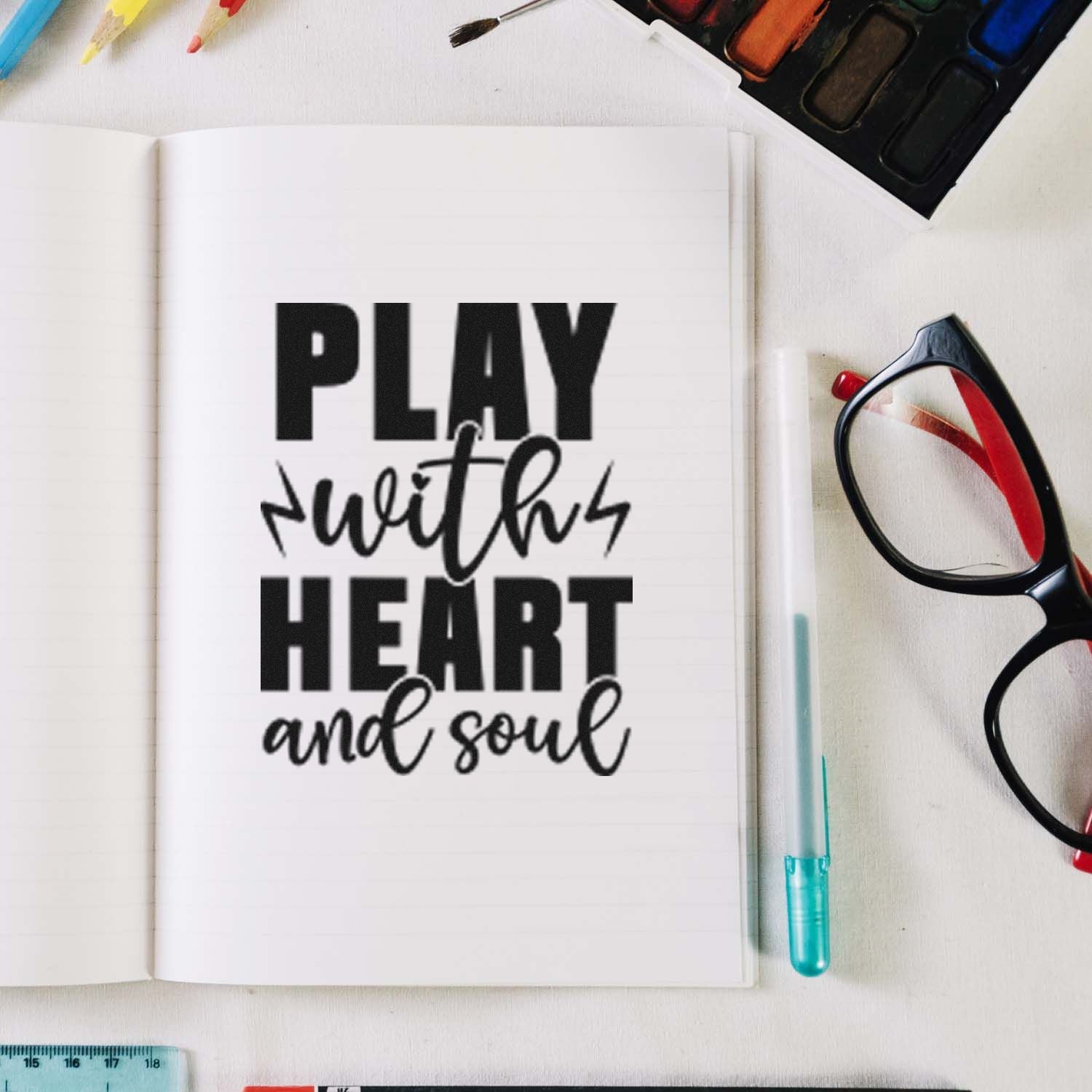 Rubber stamp quote for art journaling: Play with heart and soul in an open notebook with supplies.