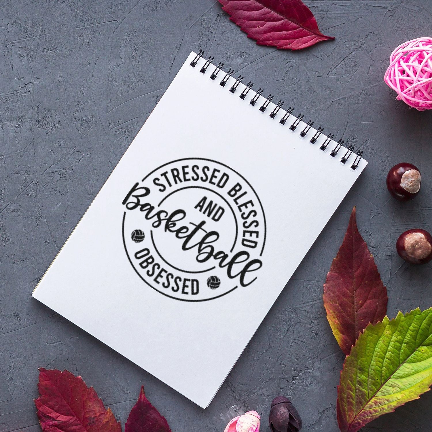 Basketball obsessed rubber stamp design on spiral notebook, perfect for handmade paper crafts, planners, and gift making.
