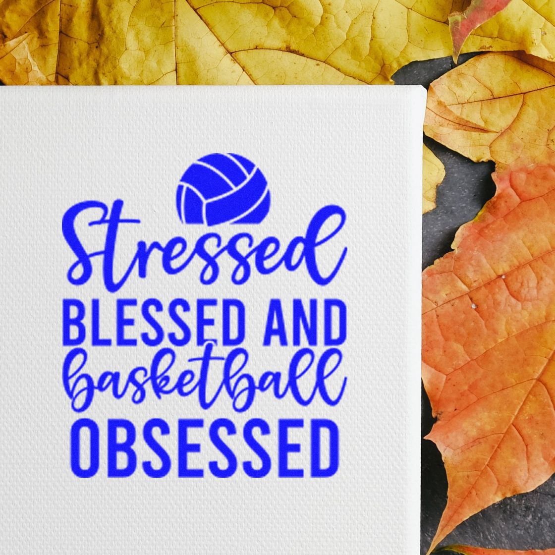 Blue custom rubber stamp design reading Stressed, Blessed and Basketball Obsessed on white paper with autumn leaves.
