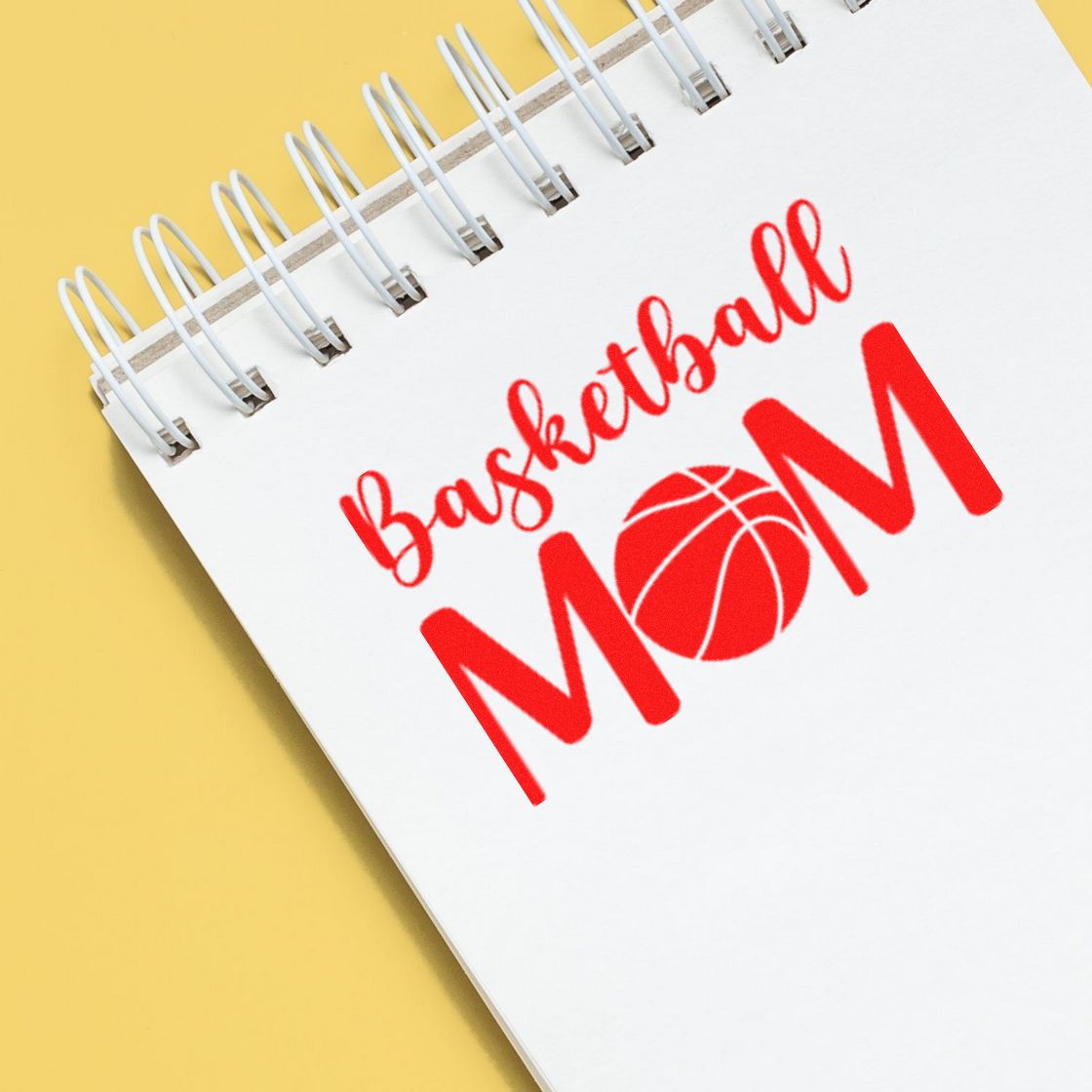 Basketball Mom rubber stamp design on notebook, featuring red sports lettering and basketball icon