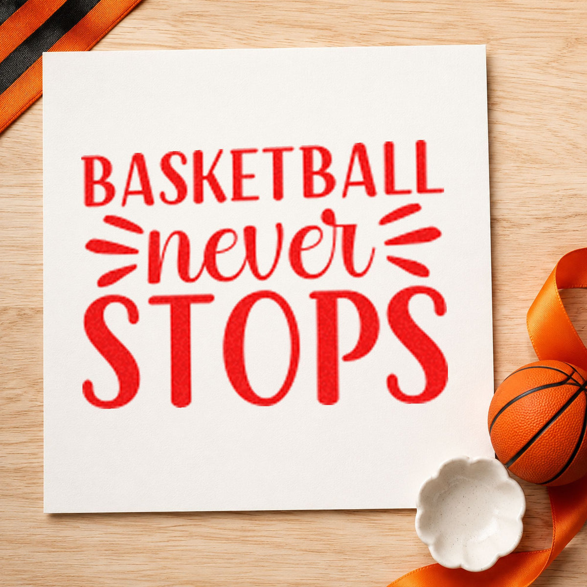 Basketball Never Stops Lettering craft stamp imprint in red ink on a handmade project, one idea being block goal cards.