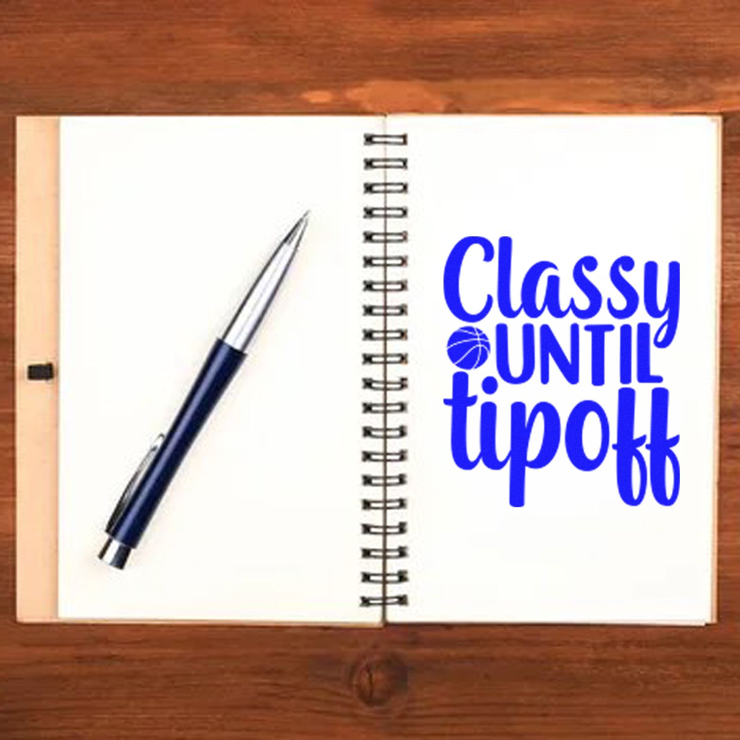 Basketball rubber stamp design reading Classy until tipoff on a notebook with pen.