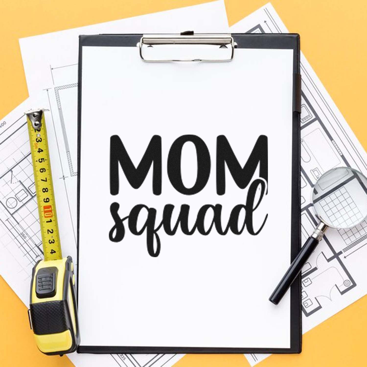 Mom Squad rubber stamp design on clipboard with blueprints, perfect for custom crafts, gifts, and DIY projects.