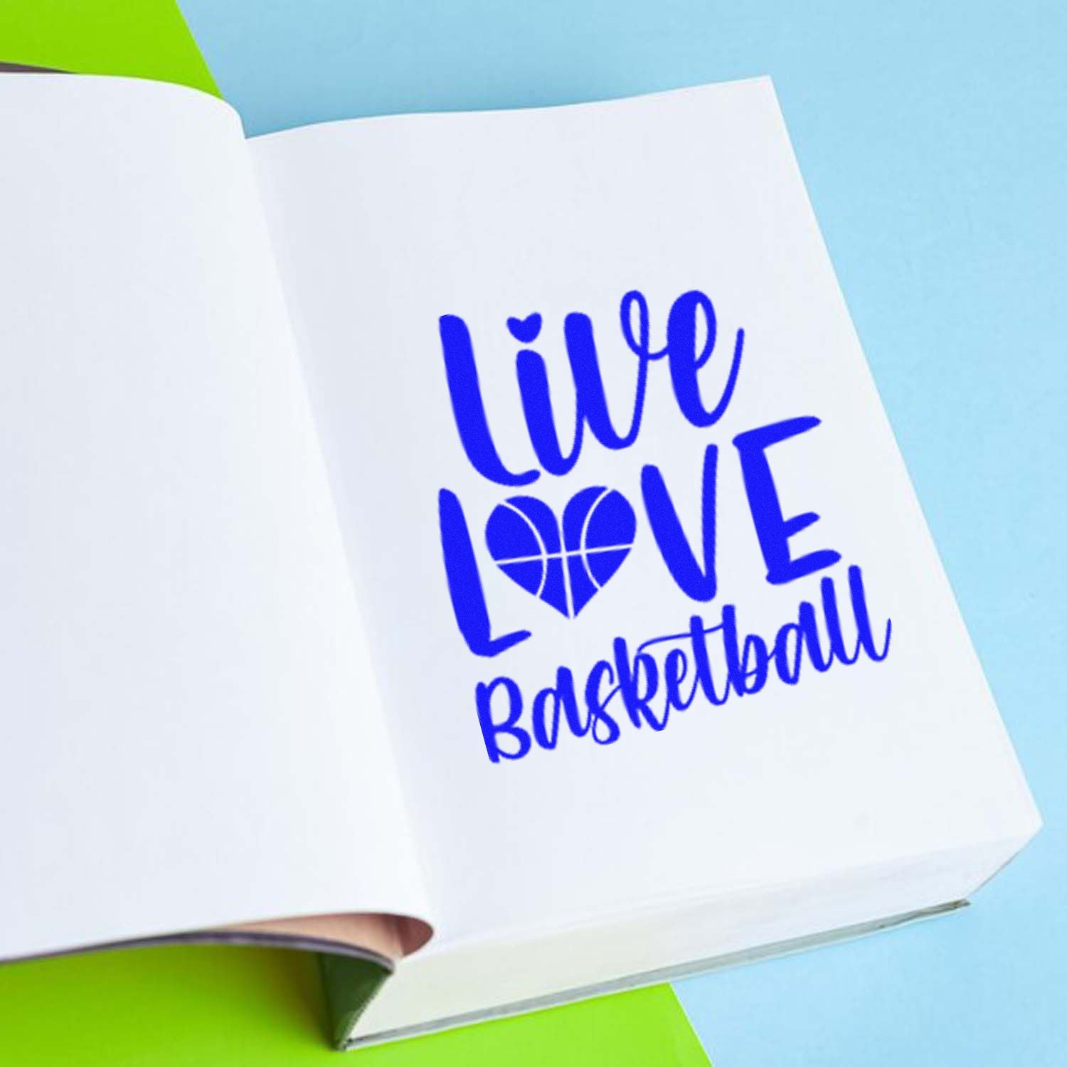 Custom rubber stamp design reading Live Love Basketball in blue ink on an open notebook page.