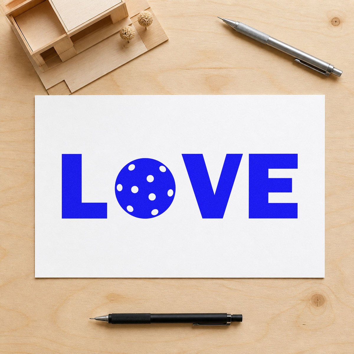 Love Pickleball Ball Letter craft stamp imprinted in blue ink on paper, a design suited to framed club lounge.