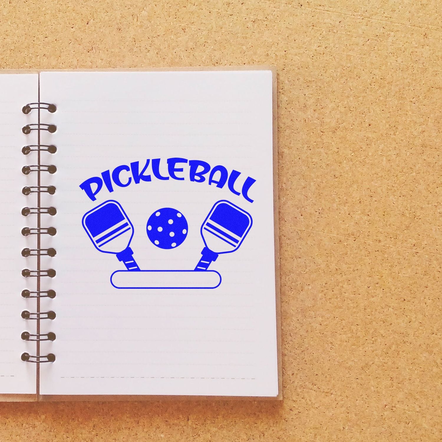 Pickleball rubber stamp design with paddles and ball on a notebook page for sports-themed crafts and journaling