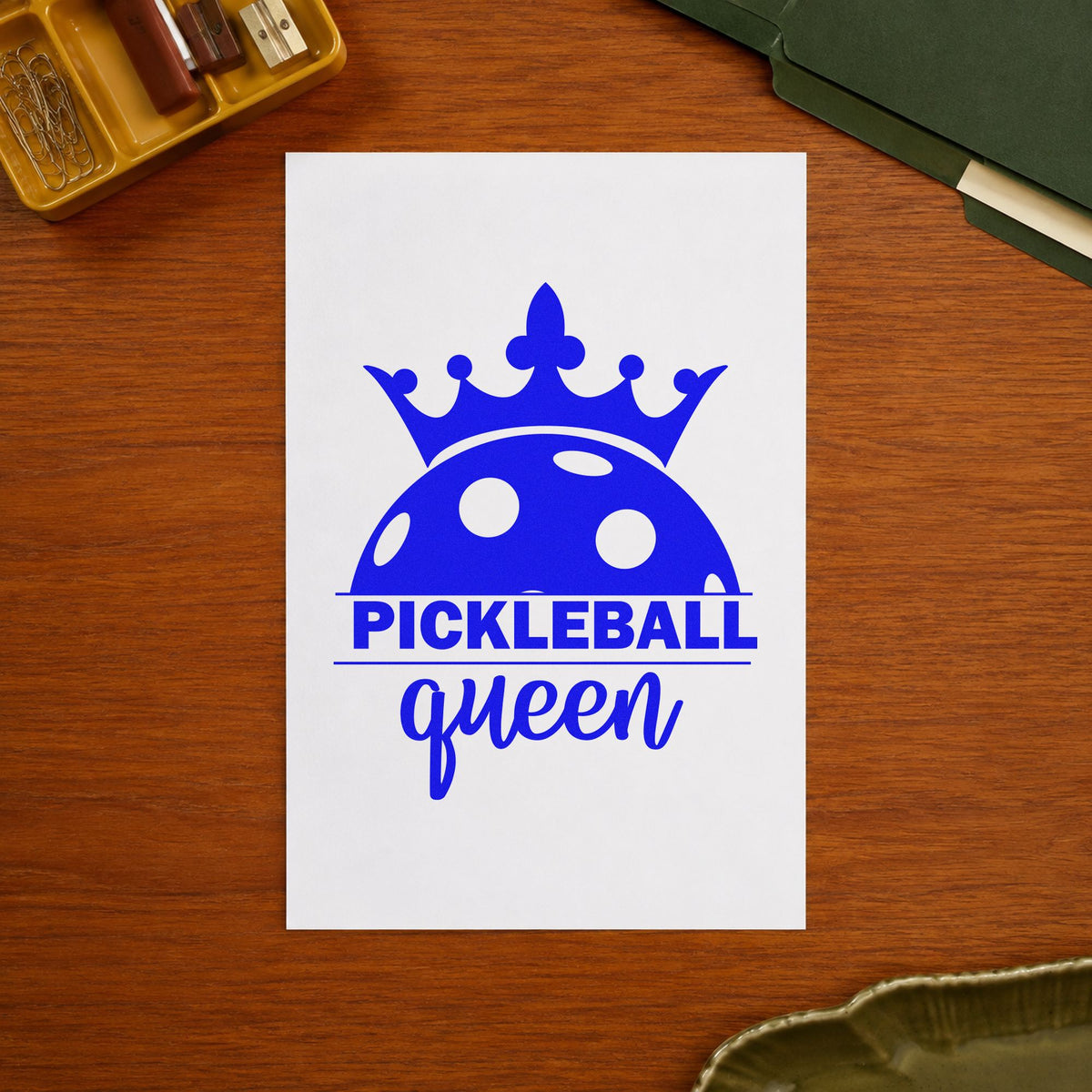 Pickleball Queen Crowned Ball craft stamp in blue ink on cardstock, an easy option for court towel printing.