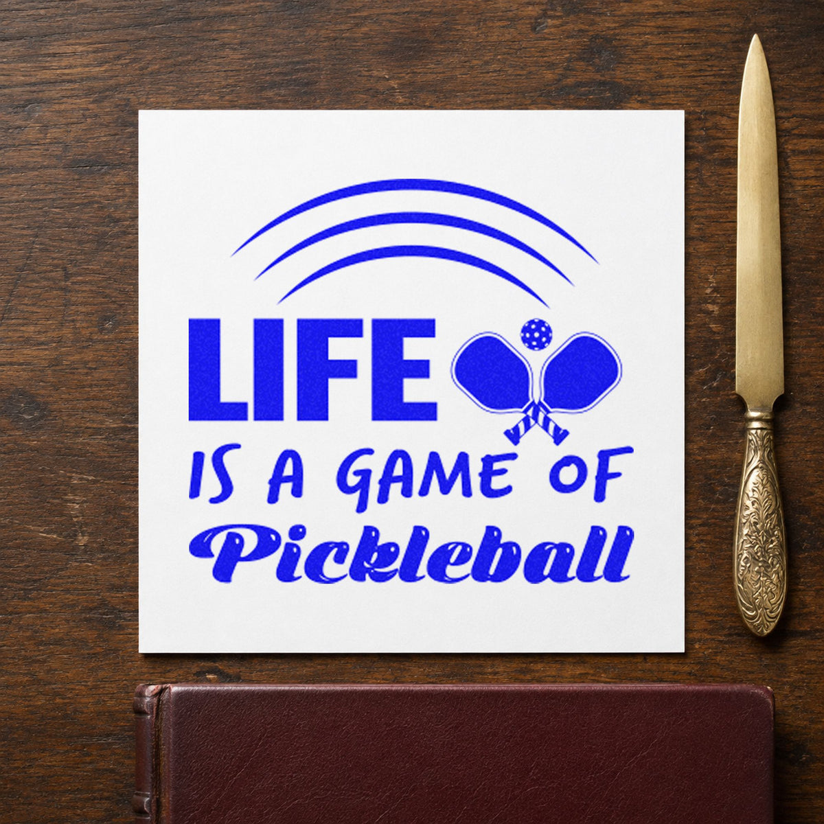 Life Game Of Pickleball craft stamp in blue ink on cardstock, an easy option for volunteer tee printing.