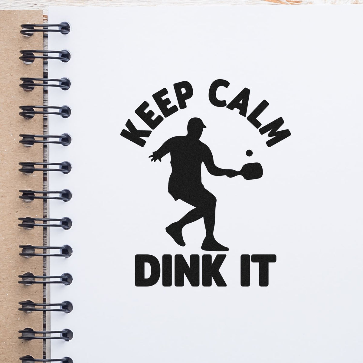 Premium Wooden Keep Calm Dink It Paddle Stamp - Vintage Pro imprint stamped in black ink. KEEP CALM DINK IT surrounds a player silhouette swinging a paddle toward a ball.
