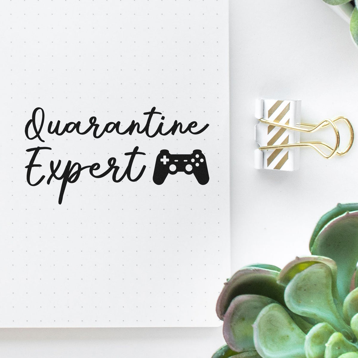 Quarantine Expert Gaming Controller Script Lettering Premium Wooden Stamp - Vintage Pro imprint stamped in black ink. Quarantine Expert appears in script beside a small game controller.