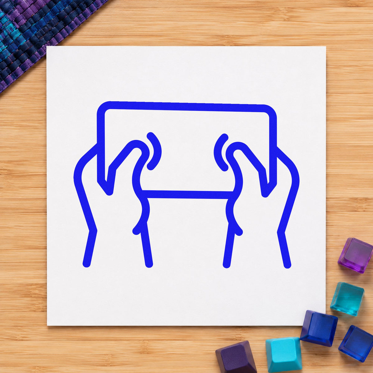 Hands Holding Outlined Tablet craft stamp imprinted in blue ink on paper, a design suited to framed kitchen shelf.