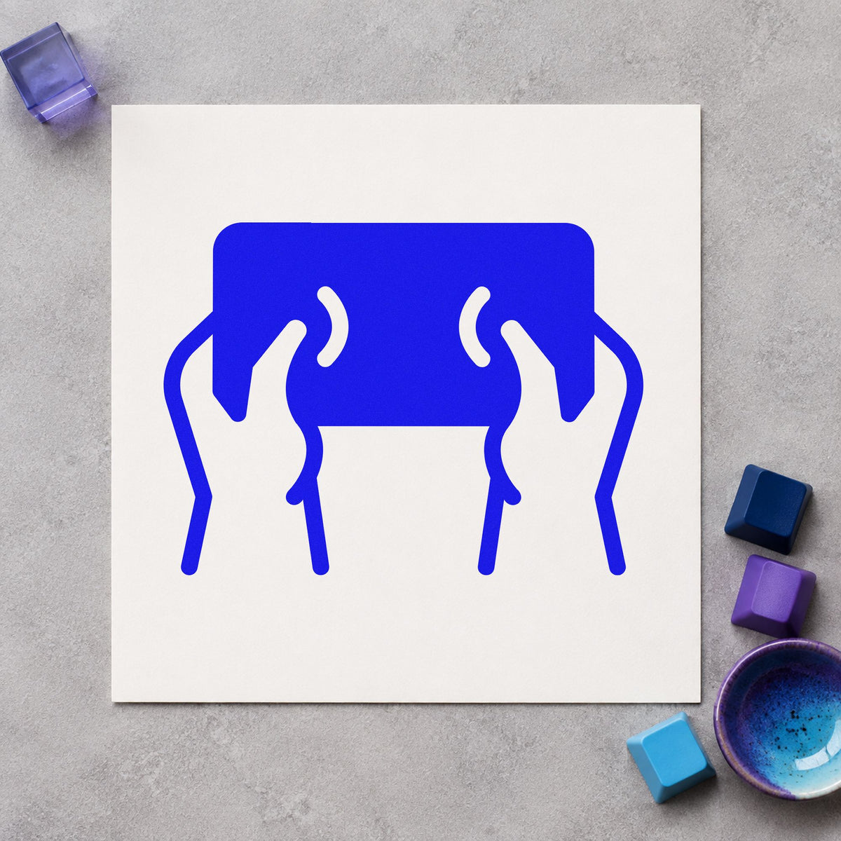 Hands Holding Dark Tablet craft stamp in blue ink on cardstock, an easy option for lap cushion printing.
