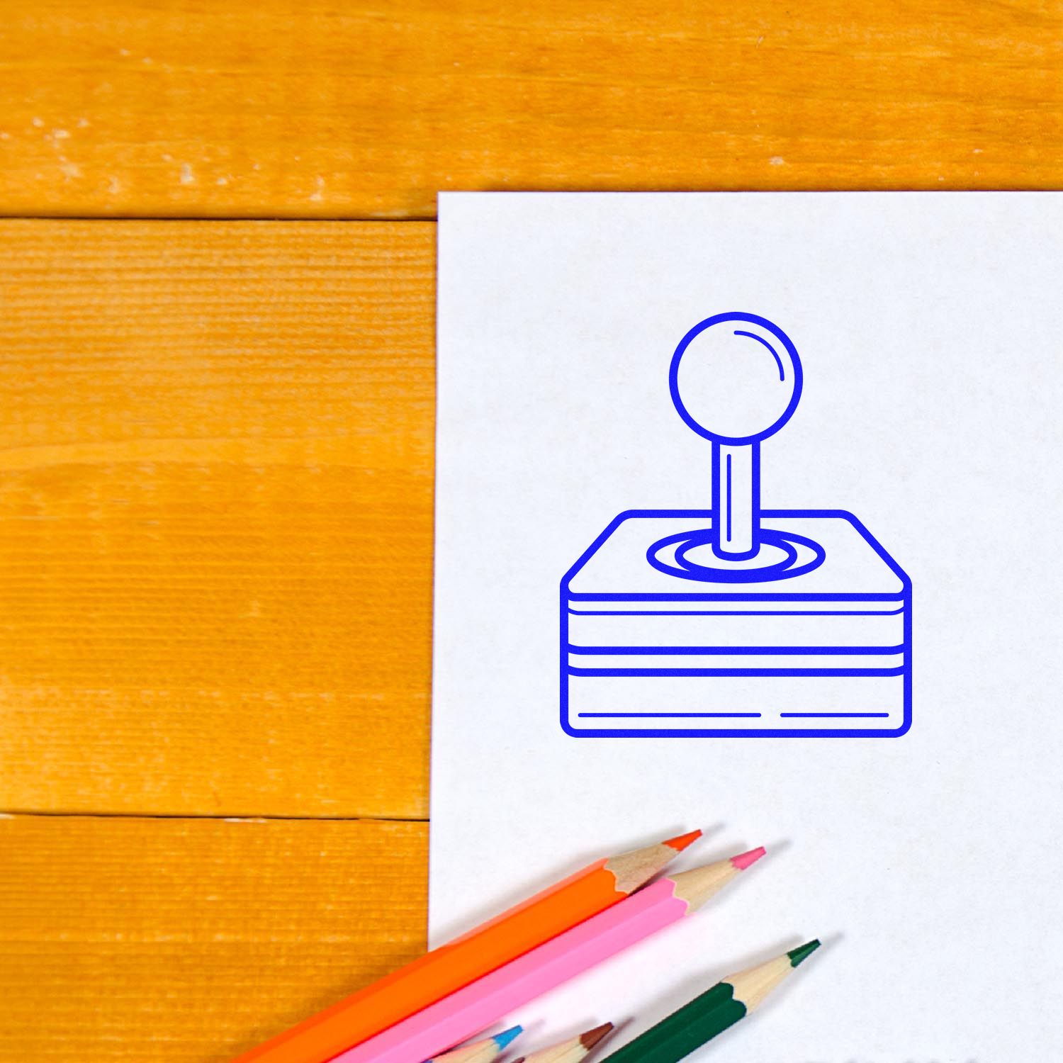 Custom rubber stamp logo mockup on white paper with colored pencils on a wooden desk